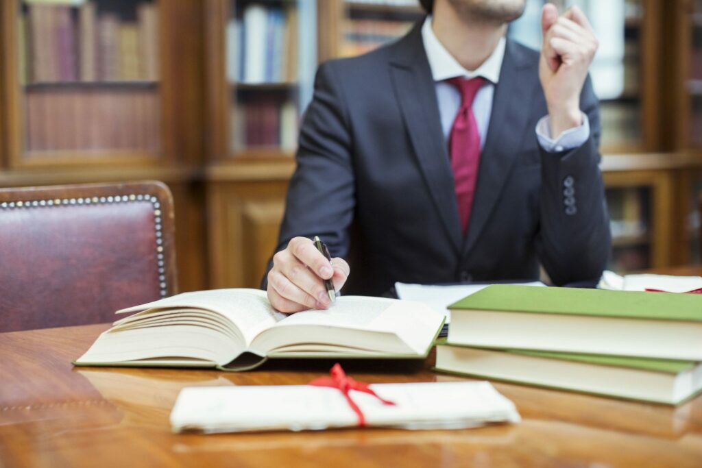 Man in suit pointing to paragraph in book with pen