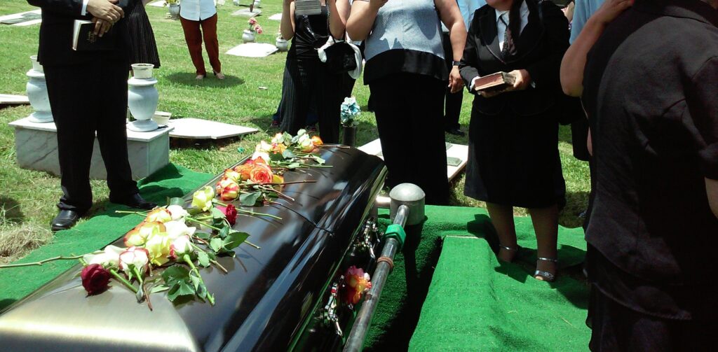 Coffin with people standing around it
