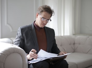Man sitting on couch reading document