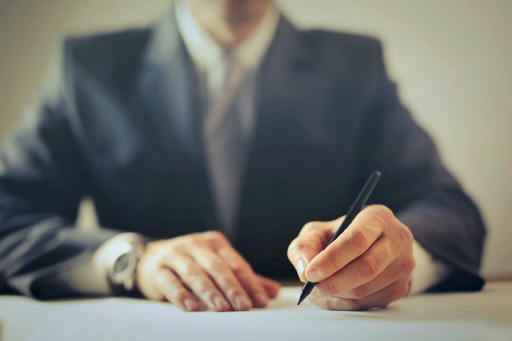 Man in suit signing paper